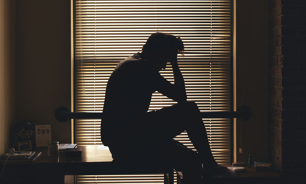 頭を抱えて悩む男